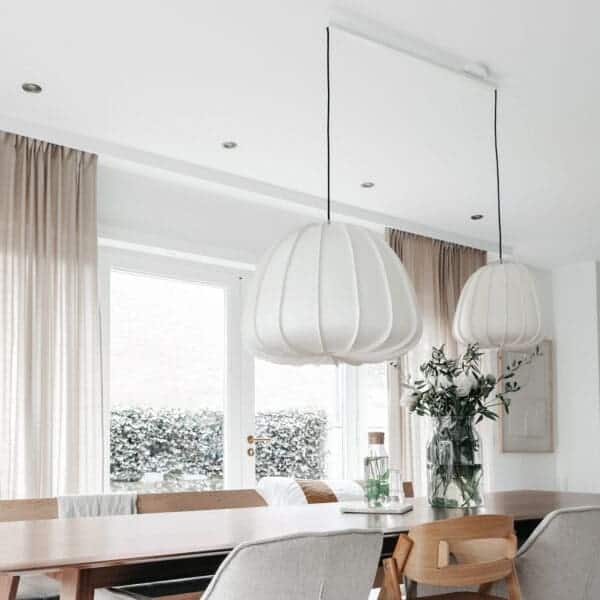 Lightswing doble blanco con dos grandes luces colgantes encima de la mesa de comedor.